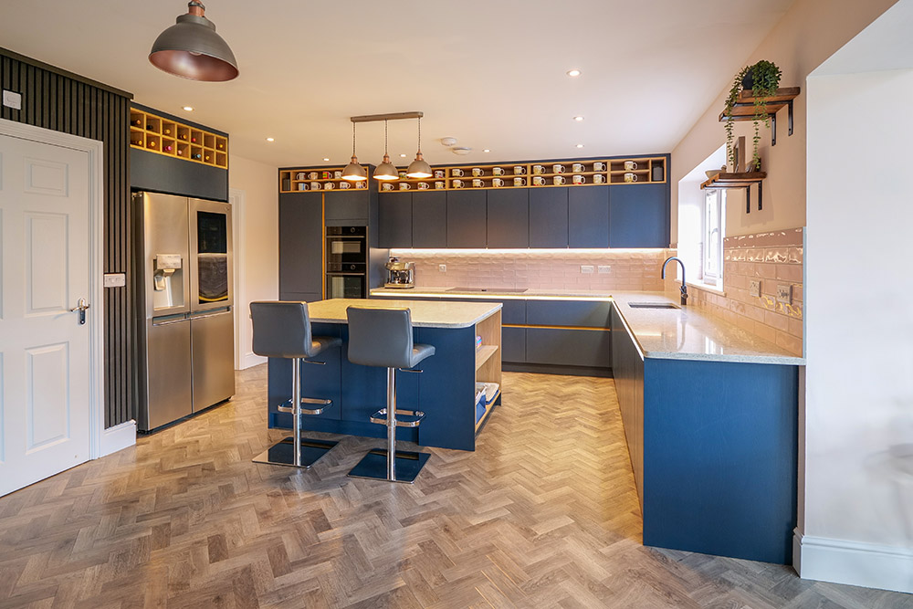 Modern Häcker kitchen featuring soft taupe gloss doors, graphite island unit and sleek quartz worktops with integrated Neff appliances