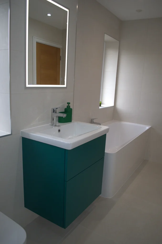 One-piece corner bath with Dansani bespoke colour wall-hung drawer unit and recessed illuminated cabinet in luxury bathroom